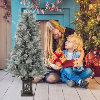 Kunstkerstboom in vintage plantenpot met rode bessen