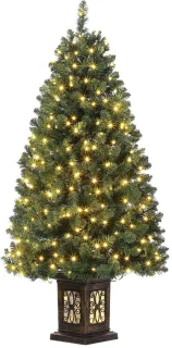 Voorgelichte kerstboom met rode bessen en sneeuwpopbasis